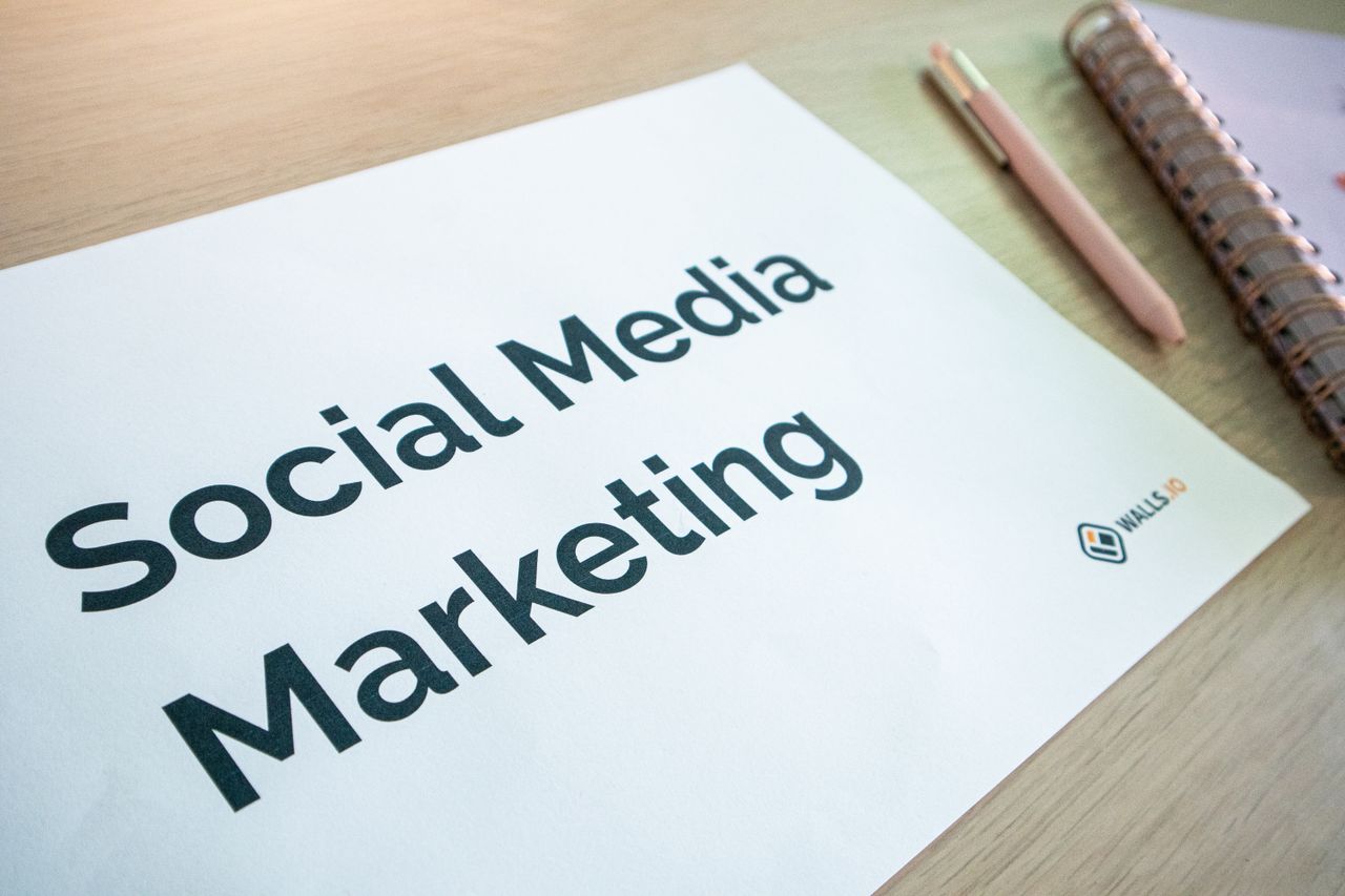 Gros plan sur un document de marketing sur les réseaux sociaux posé sur un bureau, avec un stylo et un carnet.